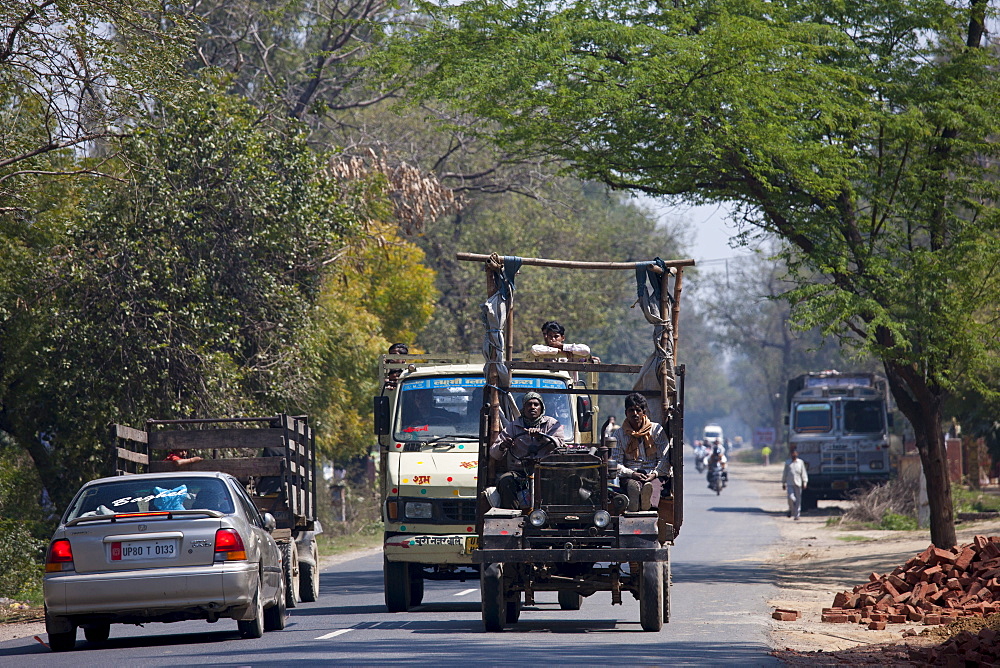 Indian workers travel in brightly coloured truck in Agra, Uttar Pradesh, India