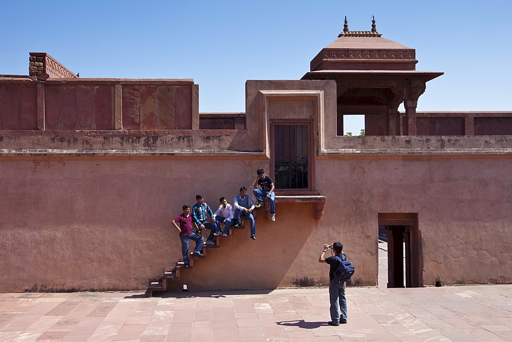 Young Indian men being photographed while visiting Fatehpur Sikri historic palace and city of Mughals, at Agra, Northern India