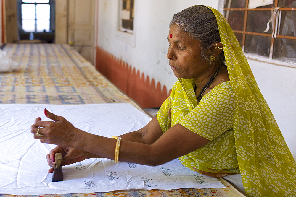 Indian woman die stamping textiles at Dastkar women's craft co-operative, the Ranthambore Artisan Project, in Rajasthan, India