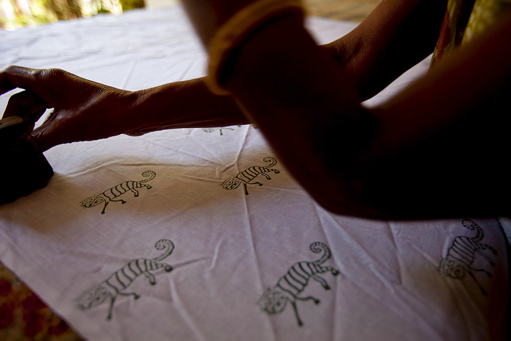 Indian woman handblock printing textiles with tiger motif at Dastkar women's craft co-operative, Ranthambore Artisan Project, Rajasthan, India