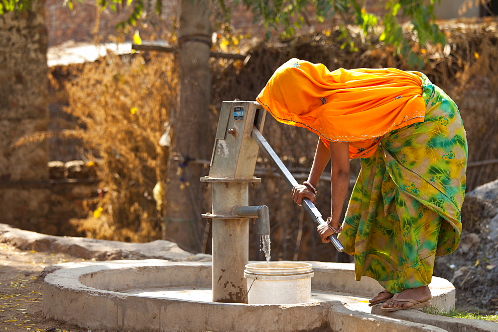 Indian woman villager pumping water from a well at Sawai Madhopur in Rajasthan, Northern India