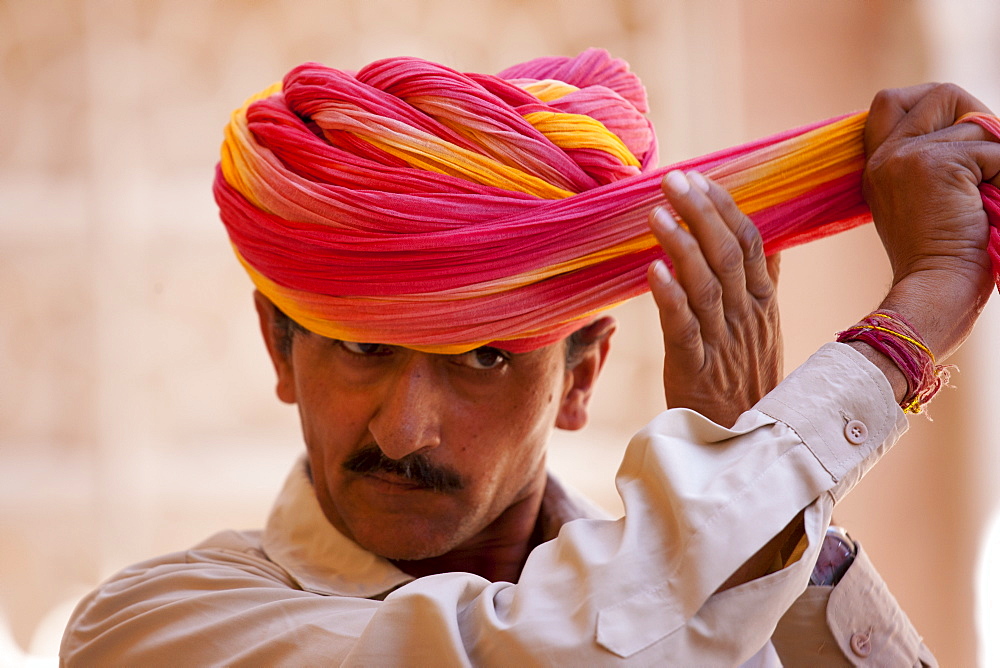 Hindu ceremonial guard putting on Rajasthani turban at Mehrangarh Fort at Jodhpur in Rajasthan, Northern India