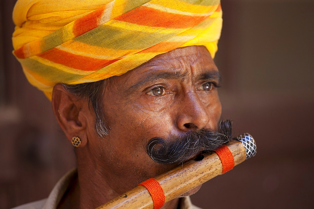 Hindu musician playing flute wind instrument at Mehrangarh Fort at Jodhpur in Rajasthan, Northern India