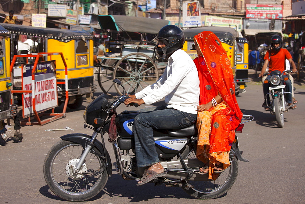 Indian couple riding motorcycle, street scene at Sardar Market at Girdikot, Jodhpur, Rajasthan, Northern India