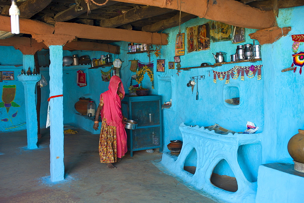 Hindu woman in traditional blue painted home in Hindu Brahman high caste village of Dhudaly  in Rajasthan, Northern India