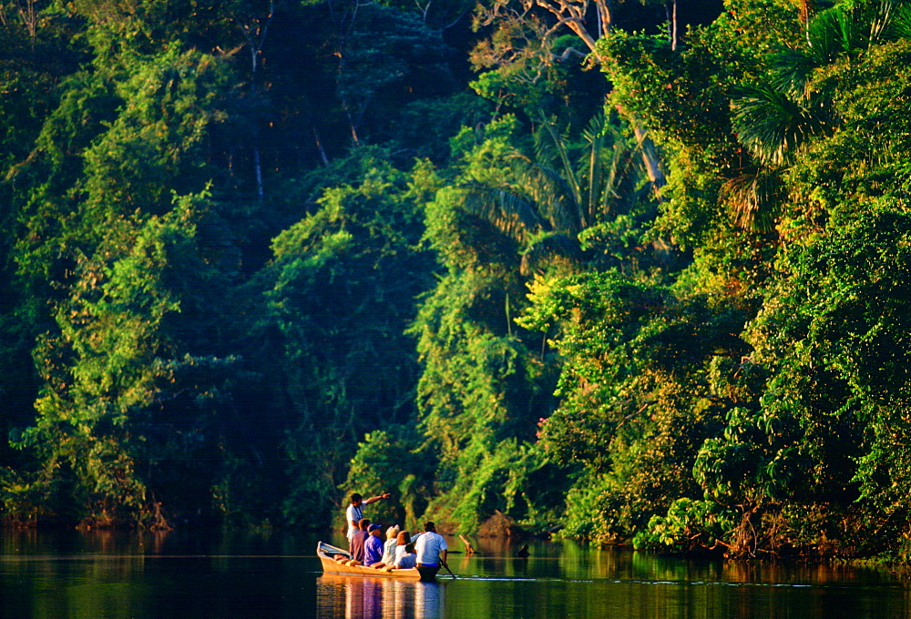 Tourists in a rowing boat with a tour guide on Lake Sandoval, Peruvian Rainforest, South America