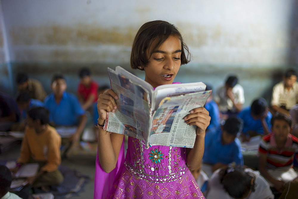 Indian girl reading aloud during English lesson at Rajyakaiya School in Narlai village, Rajasthan, Northern India