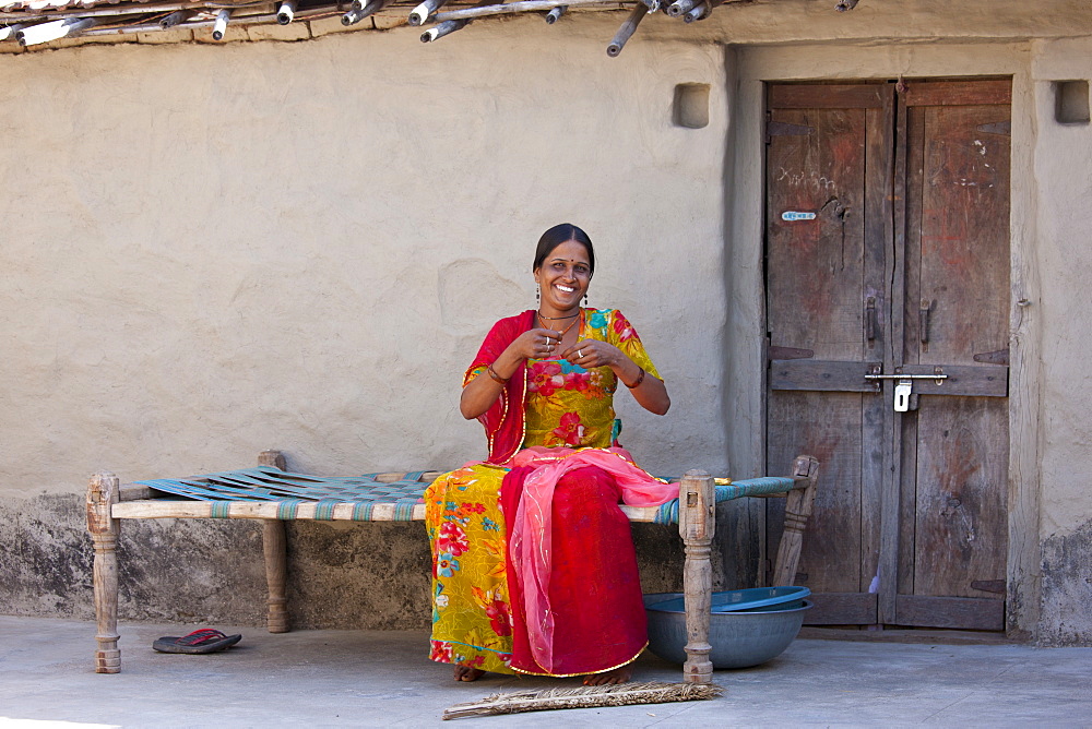 Young Indian Hindu girl sewing bridal veil at home in Tarpal in Pali District of Rajasthan, Western India