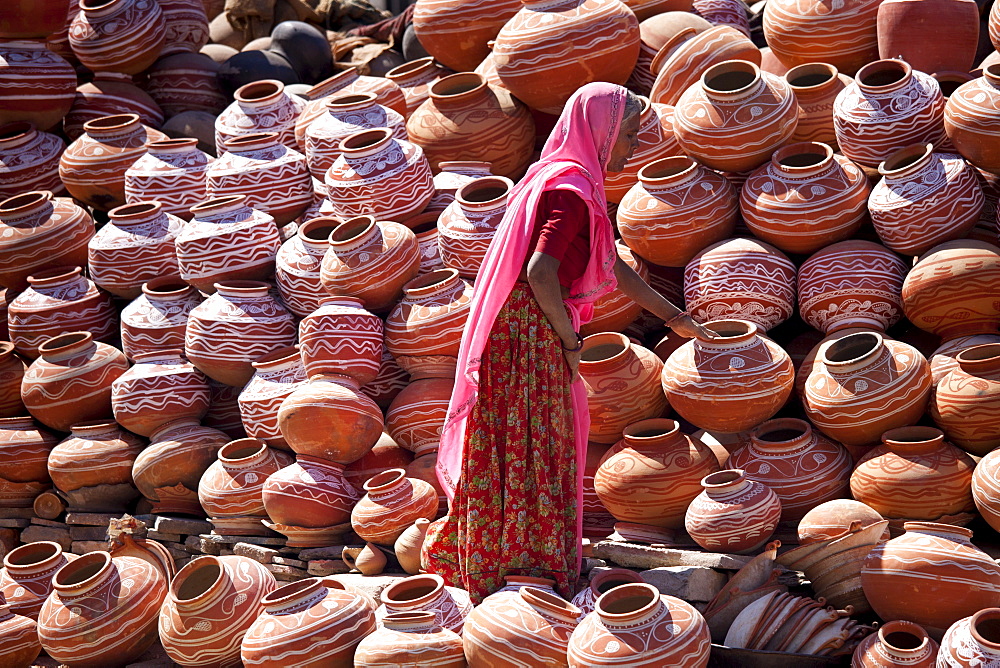 Indian woman selling clay water pots on sale in old town Udaipur, Rajasthan, Western India,