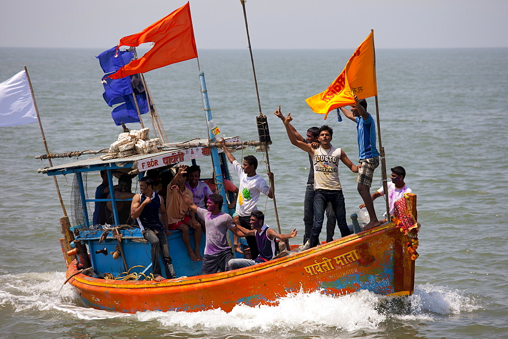 Young Indian men on boat trip celebrating Hindu Holi festival of colours at Nariman Point in Mumbai, formerly Bombay, India