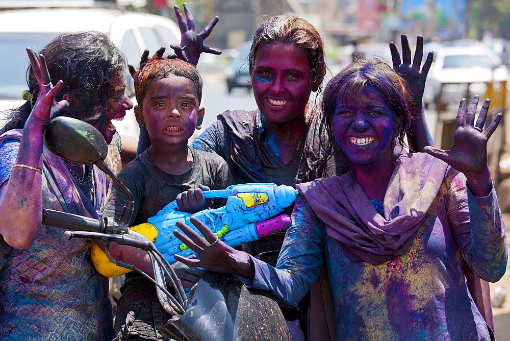 Indian woman and child celebrating annual Hindu Holi festival of colours with powder paints in Mumbai, formerly Bombay, Maharashtra, India