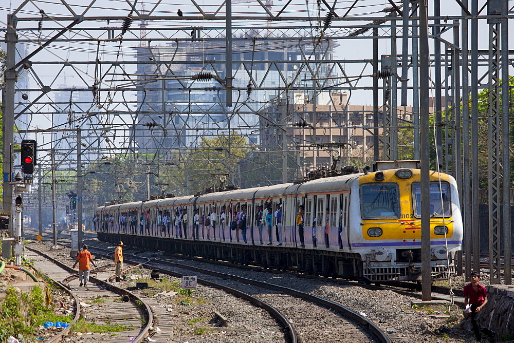 Office workers on crowded commuter train of Western Railway near Mahalaxmi Station on the Mumbai Suburban Railway, India