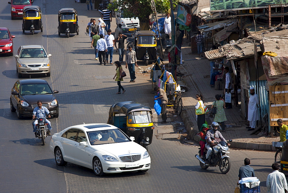 Mercedes S Class luxury saloon and auto rickshaws among traffic in Bandra near BKC Complex in Mumbai, India