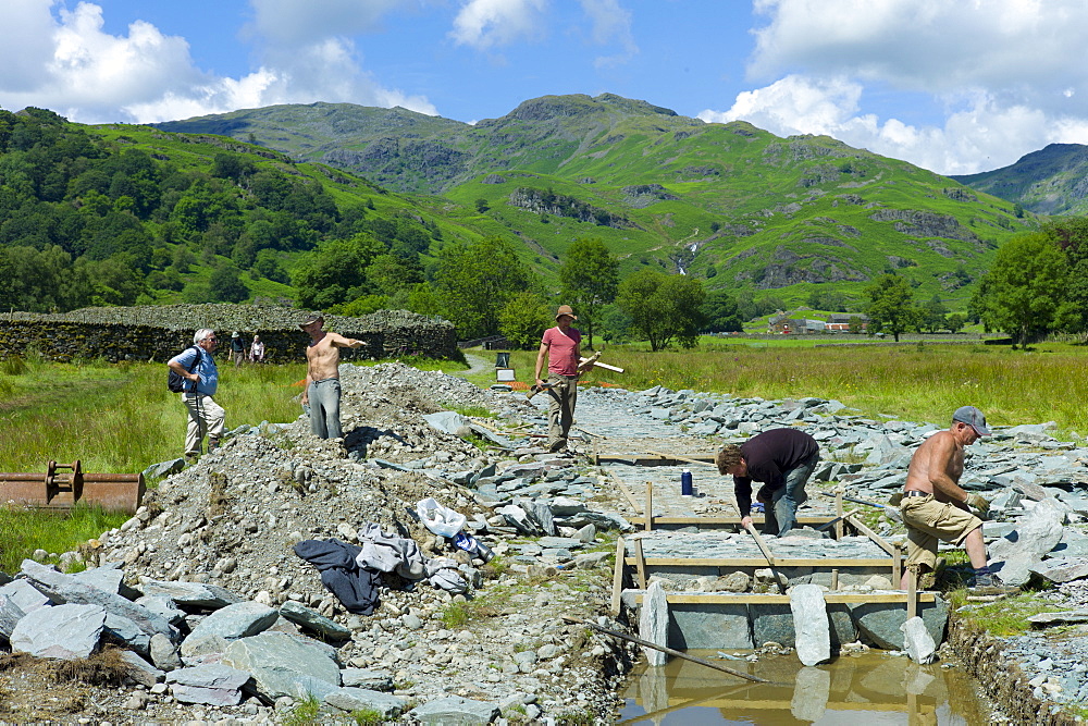 Workers pitching a path using Elterwater green slate, near Easedale Tarn in the Lake District National Park, Cumbria, UK