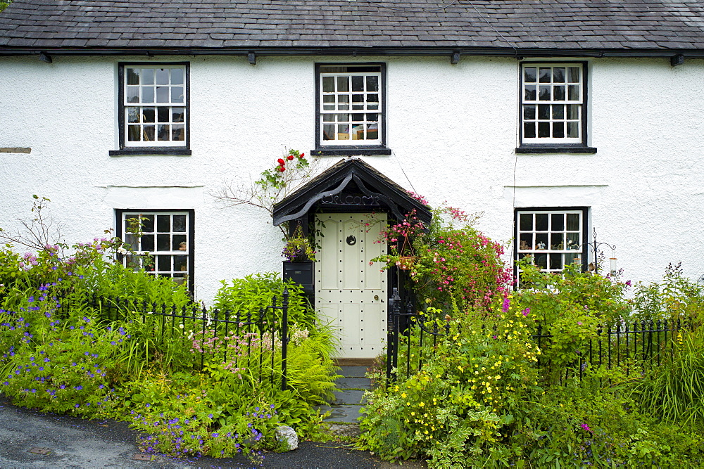 Quaint lakeland cottage with studded front door and Welcome sign, at Troutbeck in the Lake District National Park, Cumbria, UK