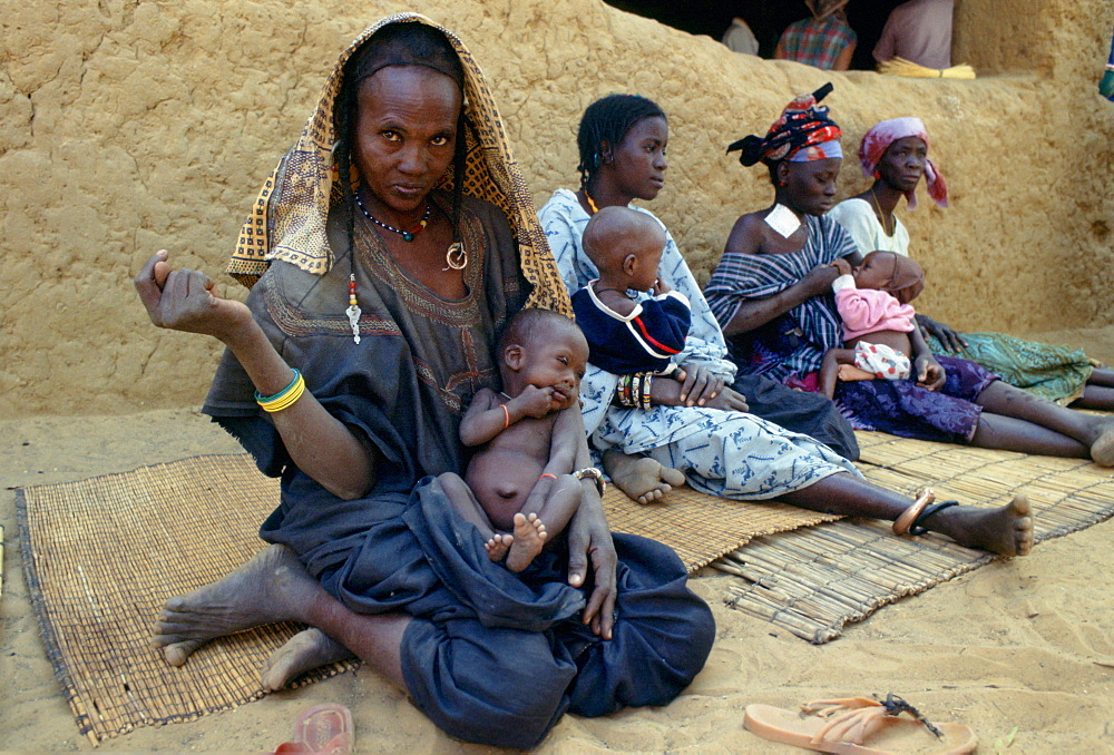 Mothers and children sitting on mats while waiting at Gorom Gorom Hospital in Burkina Faso (formerly Upper Volta)