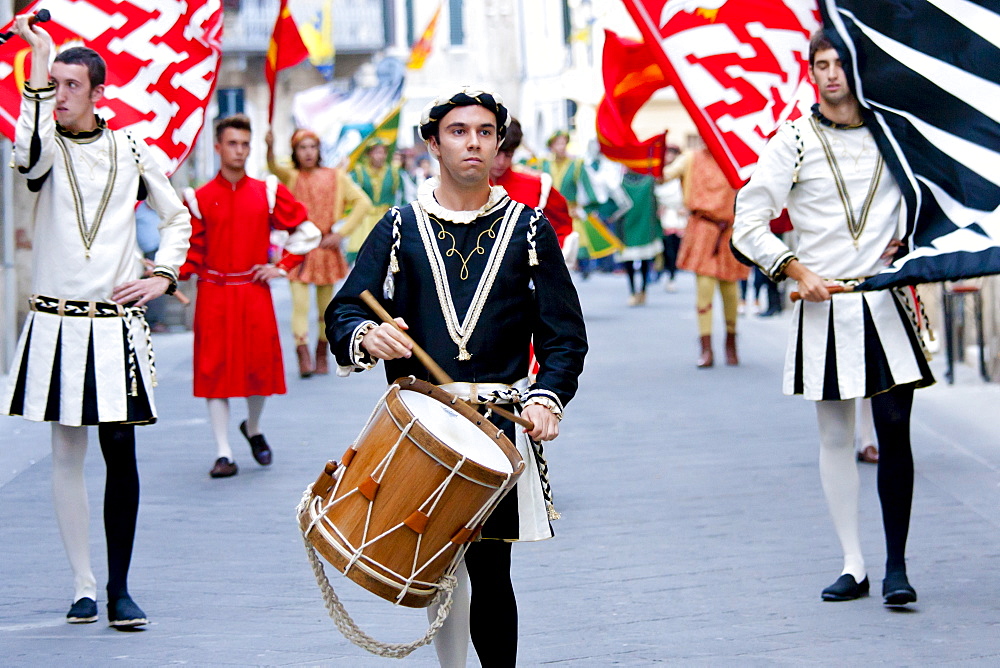 Contrada members in livery costumes for traditional parade in Asciano, inTuscany, Italy