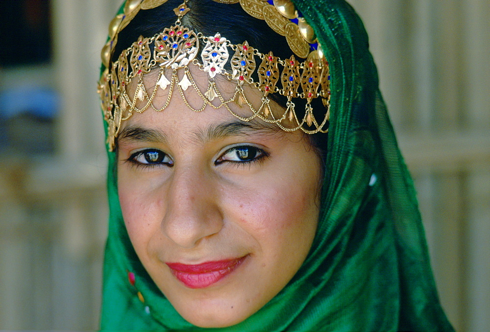 An Omani woman wearing gold jewels and a veil, Nizwa, Oman