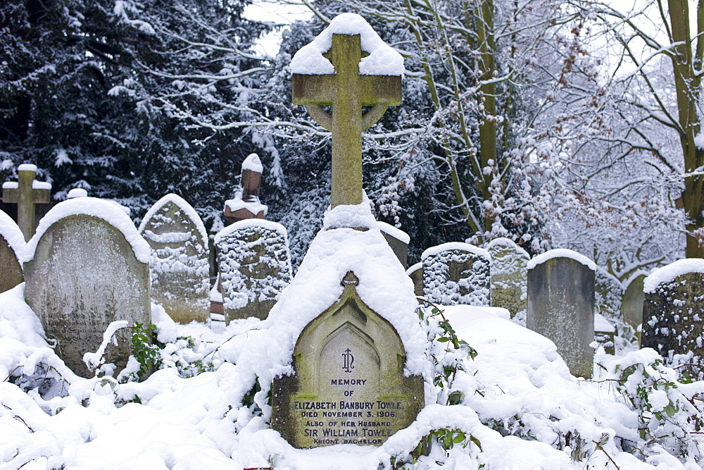 Snow-covered gravestones in Hampstead Parish Graveyard in Church Row and Holly Place in Hampstead, North London, UK