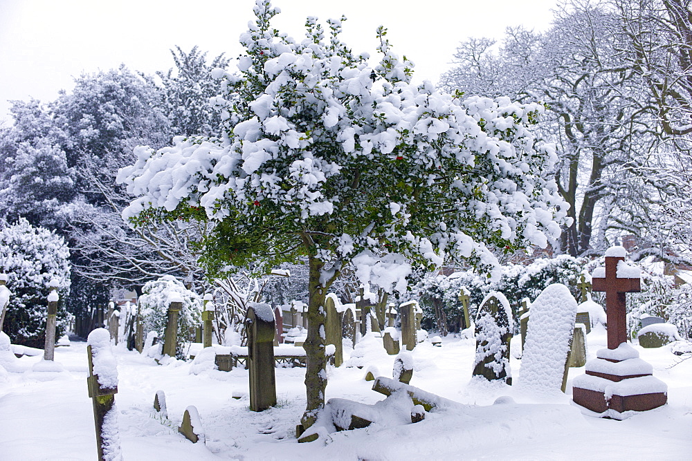 Snow-covered gravestones in Hampstead Parish Graveyard in Church Row and Holly Place in Hampstead, North London, UK