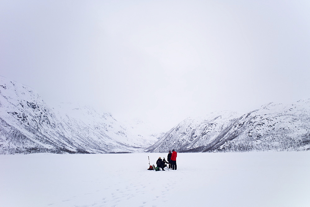 Ice-fishing on frozen lake in the Arctic Circle on Ringvassoya Island in the region of Tromso, Northern Norway