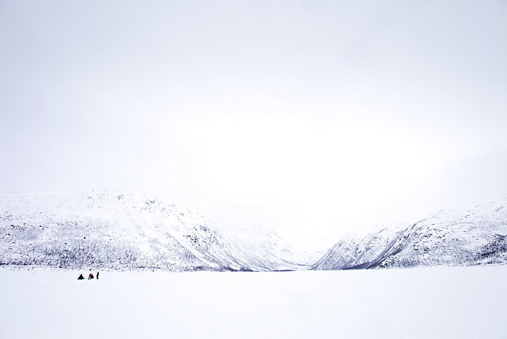 Ice fishing on frozen lake in the arctic alps in the Arctic Circle on Ringvassoya Island in the region of Tromso, Northern Norway