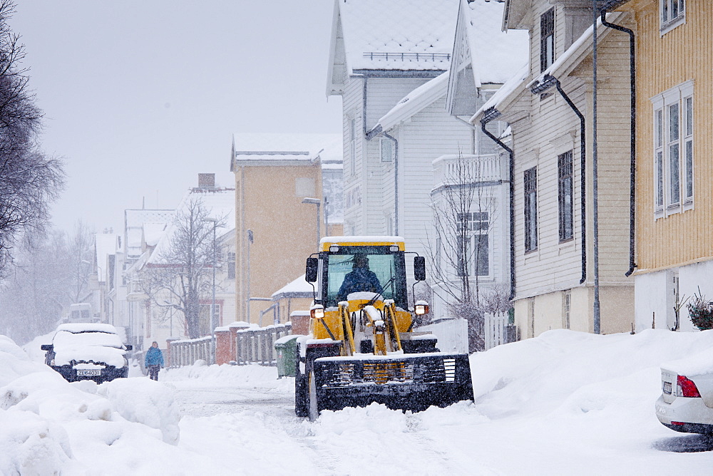 Worker drives Komatsu WA90 snow plough to clear the road in Skolegata in city of Tromso, in the Arctic Circle in Northern Norway