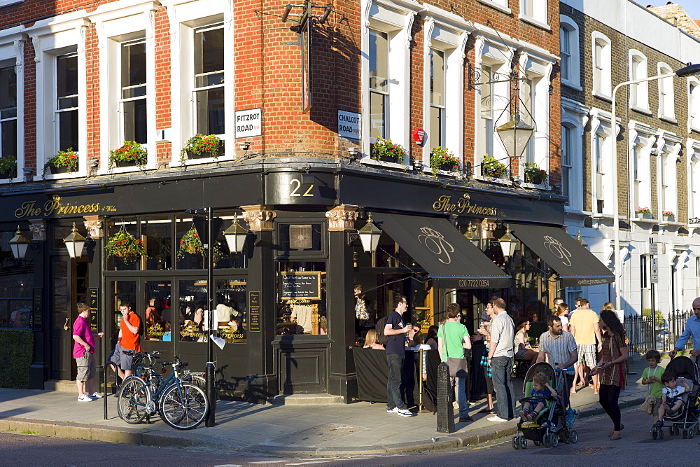 Family group passing customers enjoying warm weather at The Princess traditional London pub in Chalcot Road, Primrose Hill, London