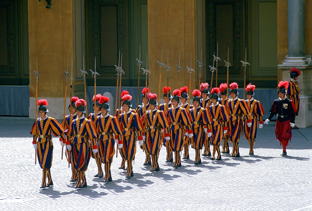 The traditional Vatican guards in St Peter's Square in Vatican City in their ornate yellow blue and red uniforms