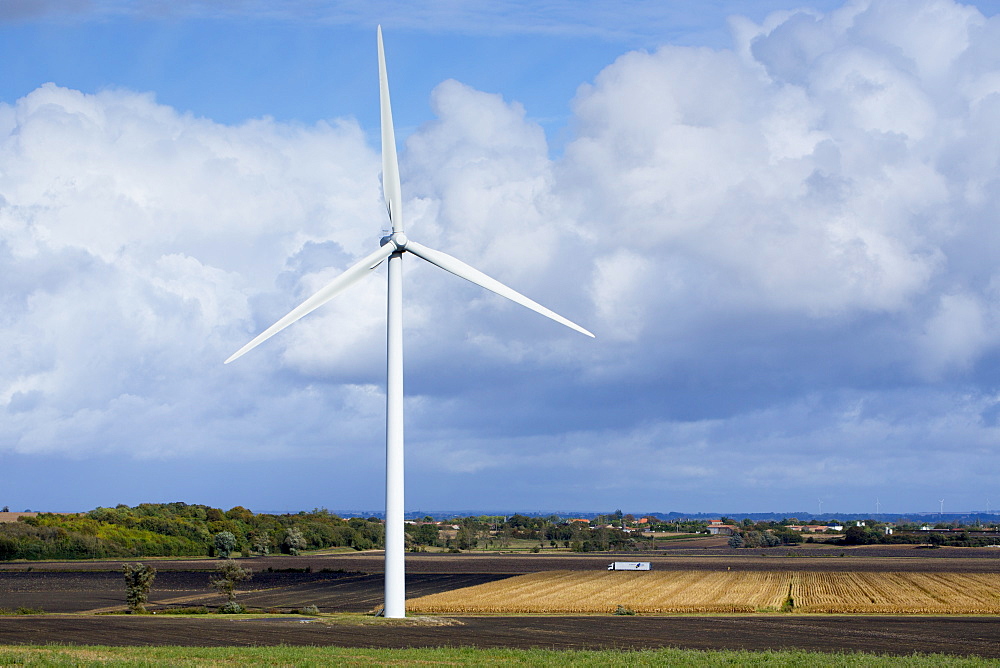 Truck on road shows great height of a wind turbine in the landscape  near Vix in the Loire Valley, France