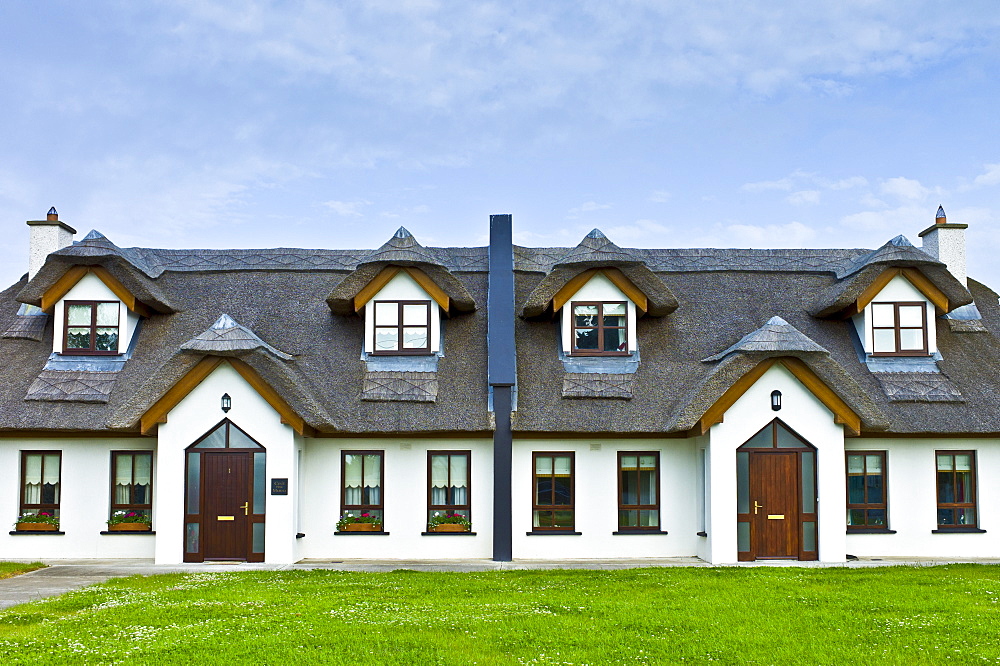 Repro thatched cottages in new development in County Wexford,  Ireland. EU funds led to 'Celtic tiger' investment in the Republic