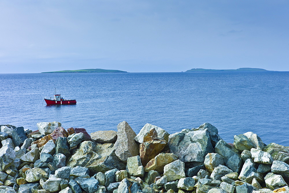 Fishing boat with Saltee Islands in background and sea defences, Kilmore, County Wexford, Southern Ireland