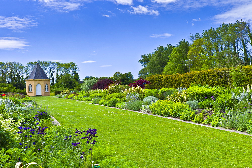 Garden at Ballymaloe Cookery School with Gothic style summer house and perennial borders, County Cork, Ireland