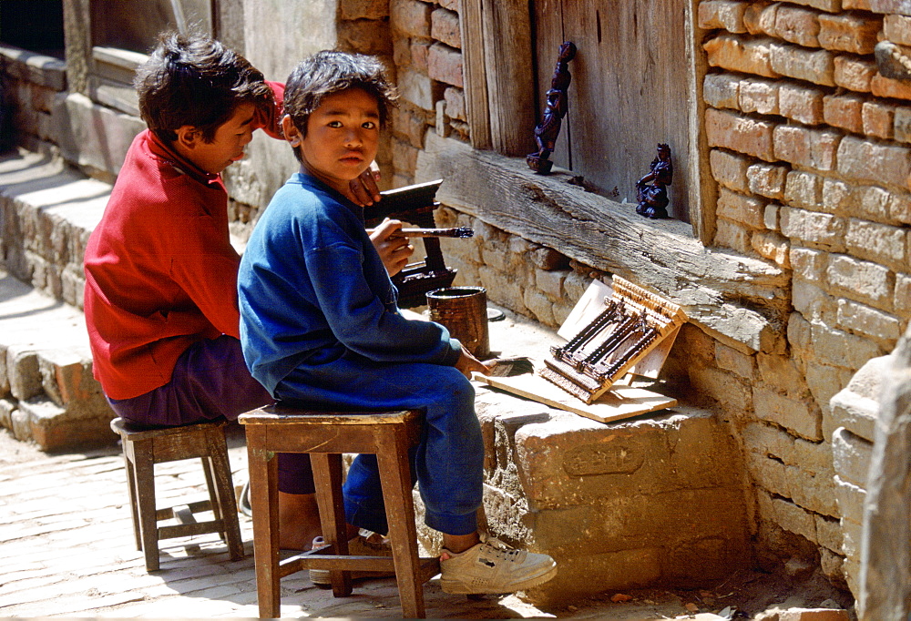 Young child workers painting carvings, Bhaktapur, Nepal