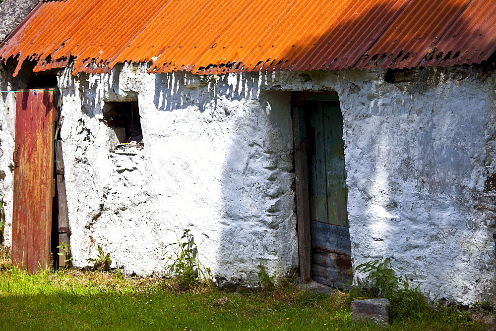 Whitewashed barn with rusty corrugated iron roof in County Cork, Ireland