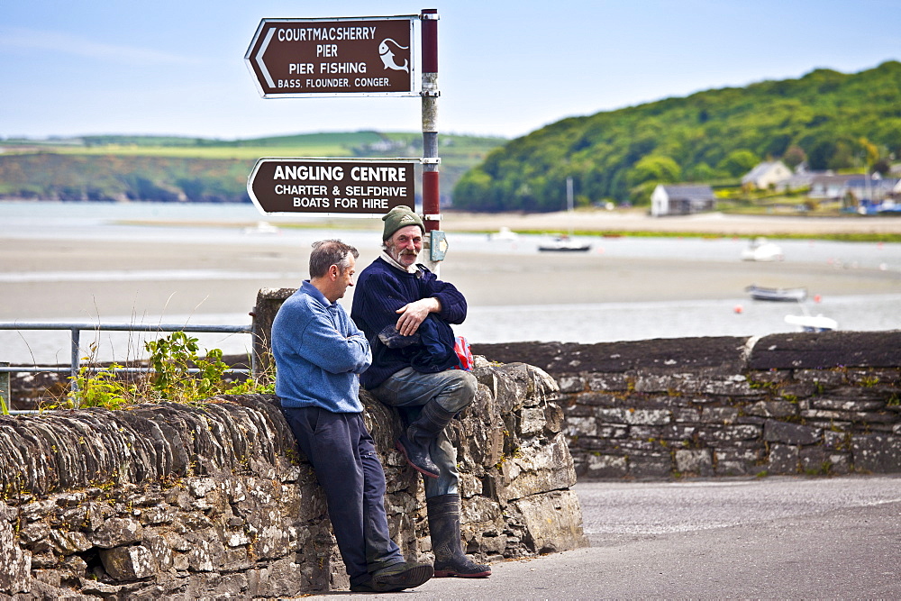 Locals chatting in the Gaelic language on the quayside at Courtmacsherry in County Cork, Ireland