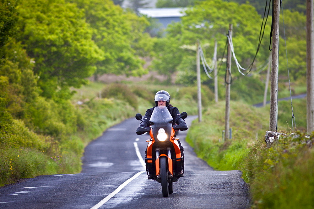 Motorcyclist in country lane in County Clare, West of Ireland