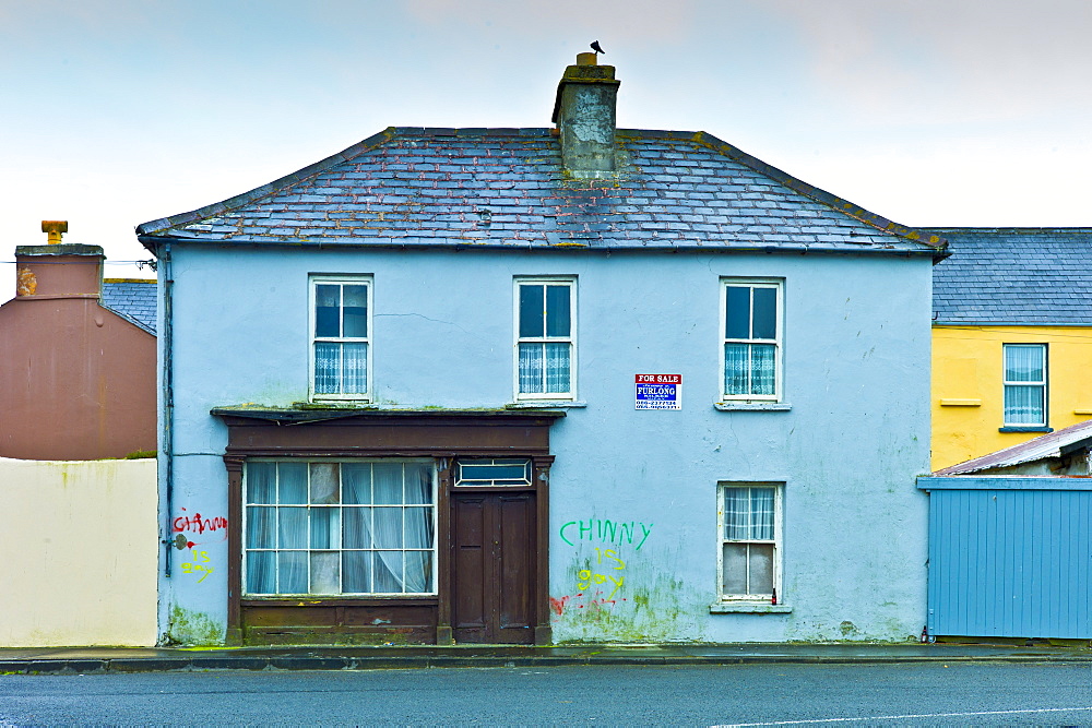 Graffiti on house with shop front for sale in Kilkee, County Clare, West of Ireland