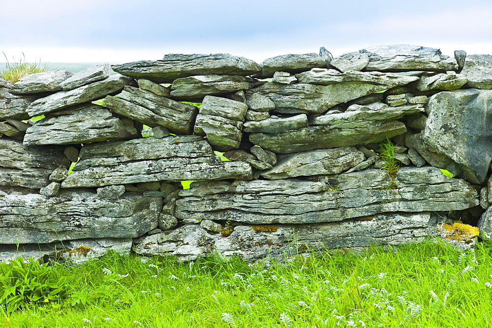 Traditional dry stone wall, stones laid flat, in field in The Burren, County Clare, West of Ireland