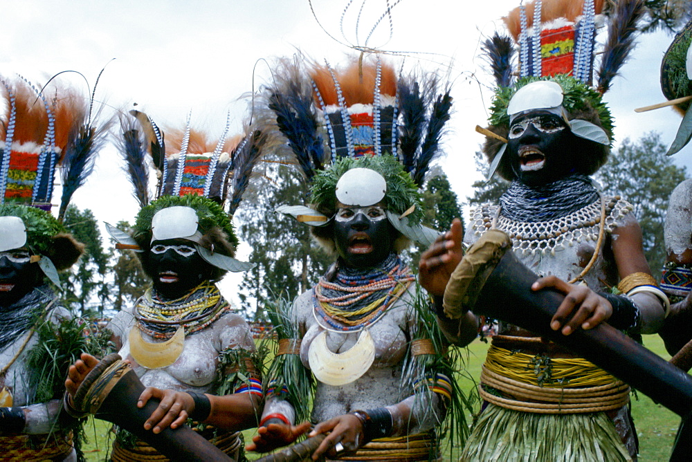 Culture in Papua New Guinea - women singing and making music at a sing sing meeting of tribes.