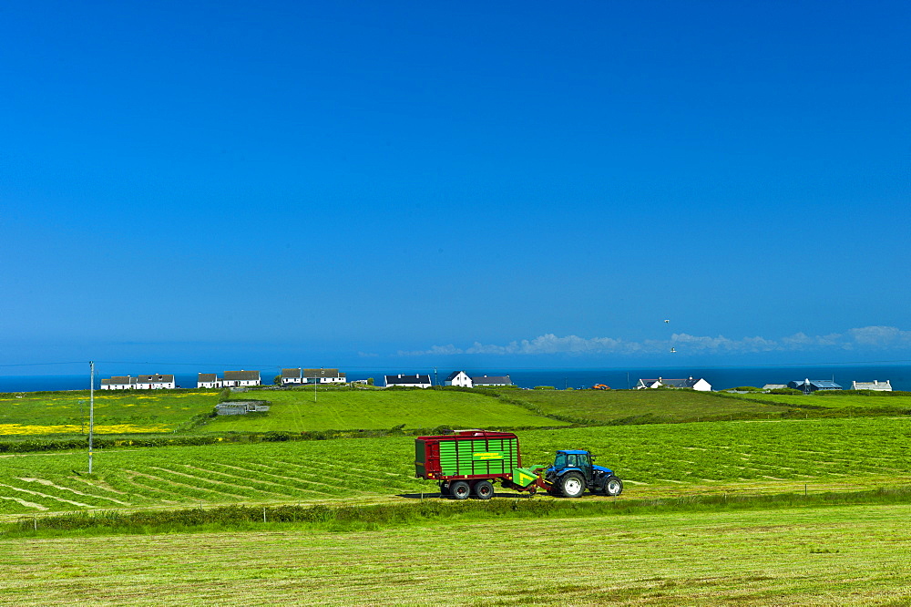 Tractor and trailer at work in field near Doonbeg, County Clare, West of Ireland