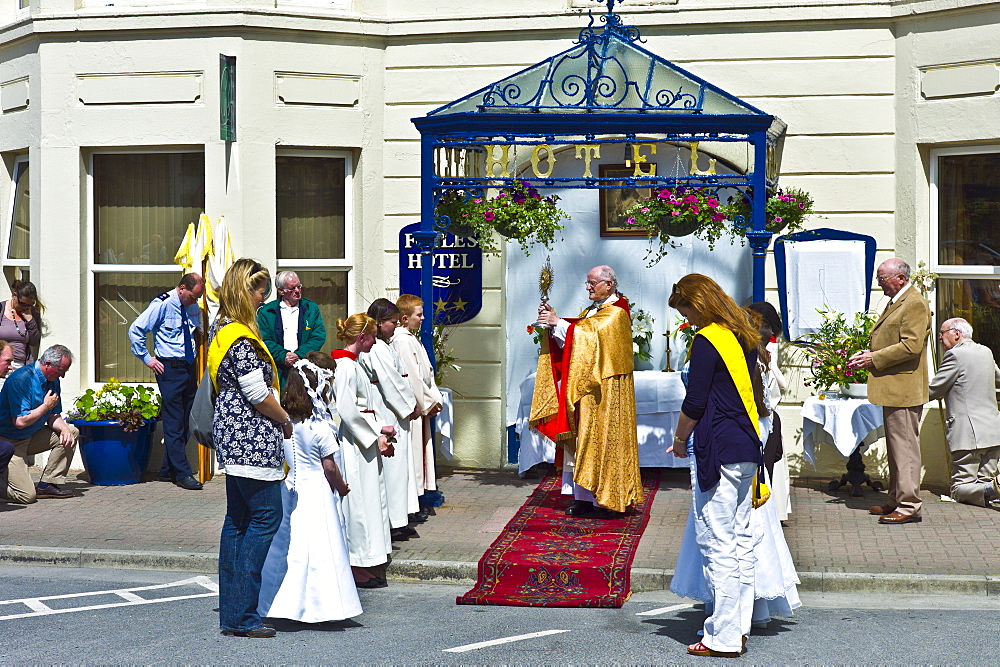 Priest carries Blessed Sacrament in Corpus Christi catholic traditional Benediction ceremony in Clifden, County Galway, Ireland