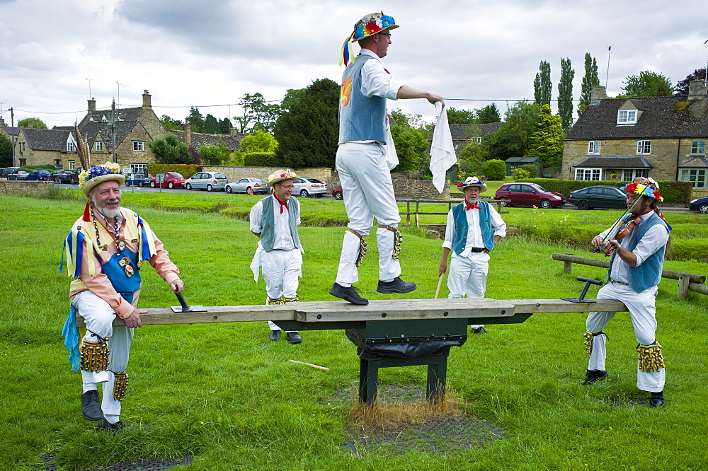 Morris dancers, Icknield Way Morris Men, in children's playground at The Kings Head Pub, Bledington, Oxfordshire, UK