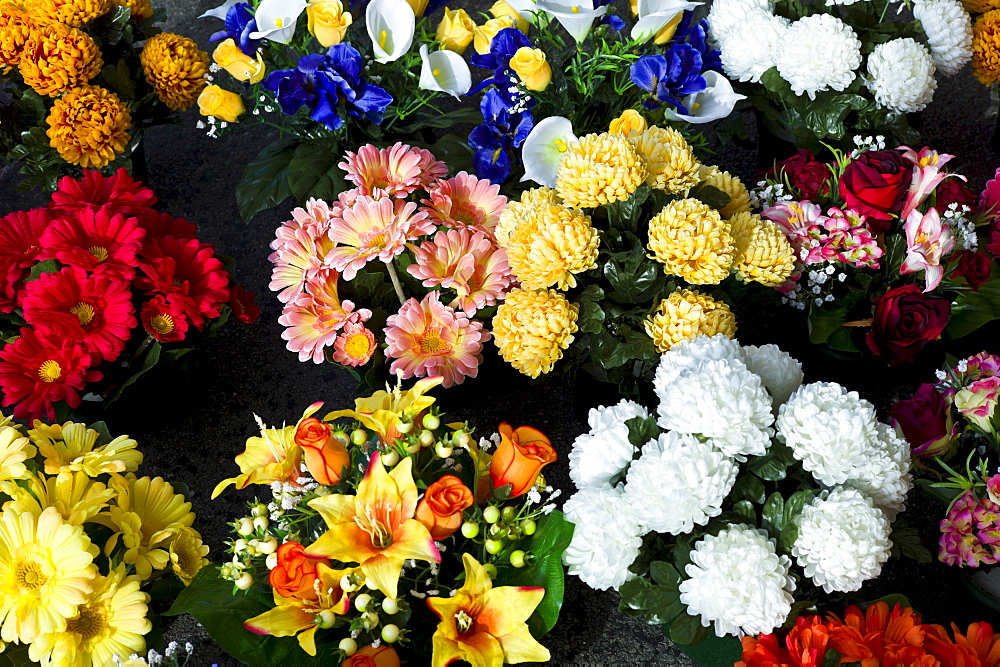 Fabric artificial flowers gerbera, chrysanthemum, lilies on sale at market in La Reole, Bordeaux region of France