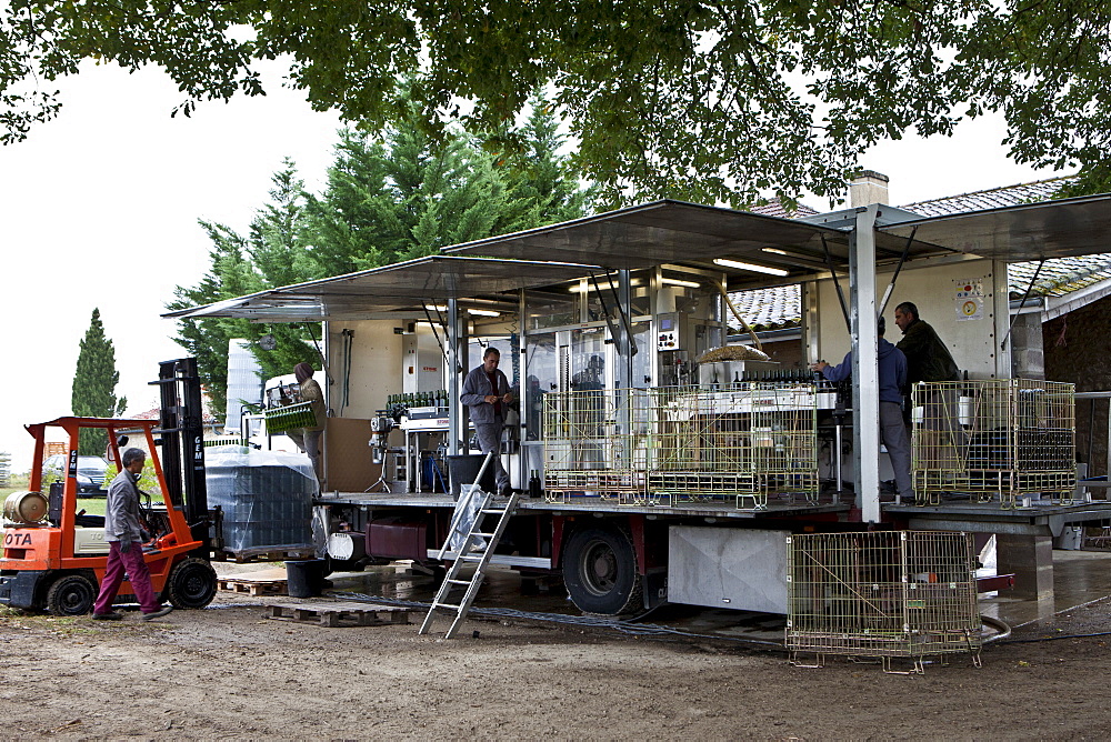 Wine bottling truck with mobile bottling line at Chateau Fontcaille Bellevue vineyard in Bordeaux region of France