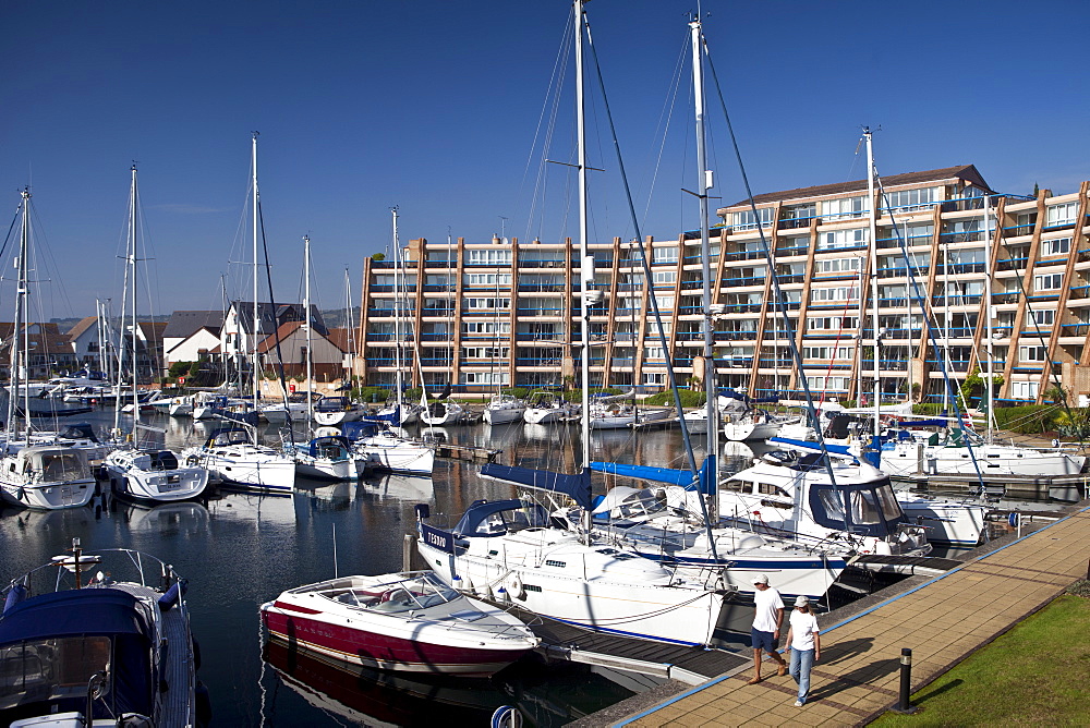 People passing yachts and power boats moored at Port Solent marina, near Portsmouth, South Coast of England, UK