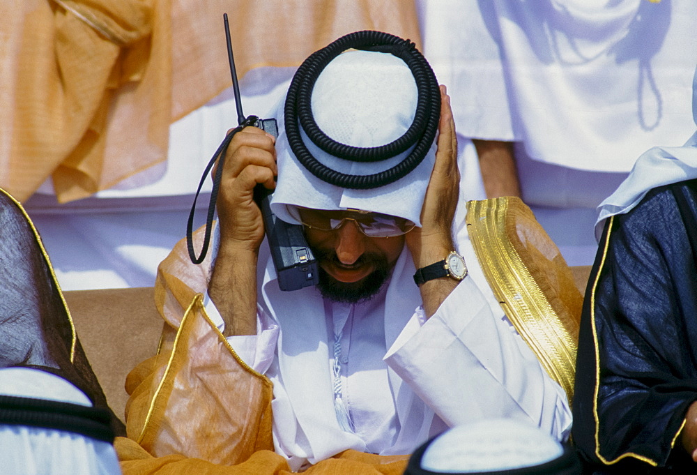 Arab using two-way radio to communicate during parade of armed forces in Abu Dhabi, United Arab Emirates