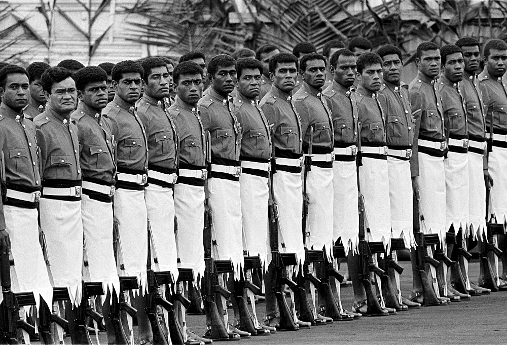 Soldiers in traditional uniforms wearing skirts in military parade in Fiji, South Pacific