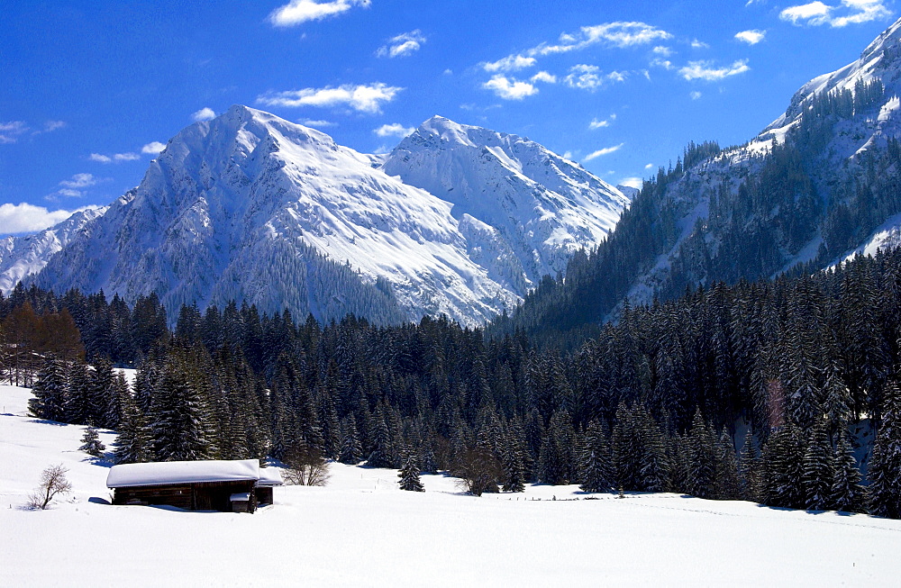 Snow covered barns in the meadows below the Alps at Klosters - Amongst the Silvretta group of the Swiss Alps. Road to Silvretta.Mountain at right is P.Linard 3411 metres high