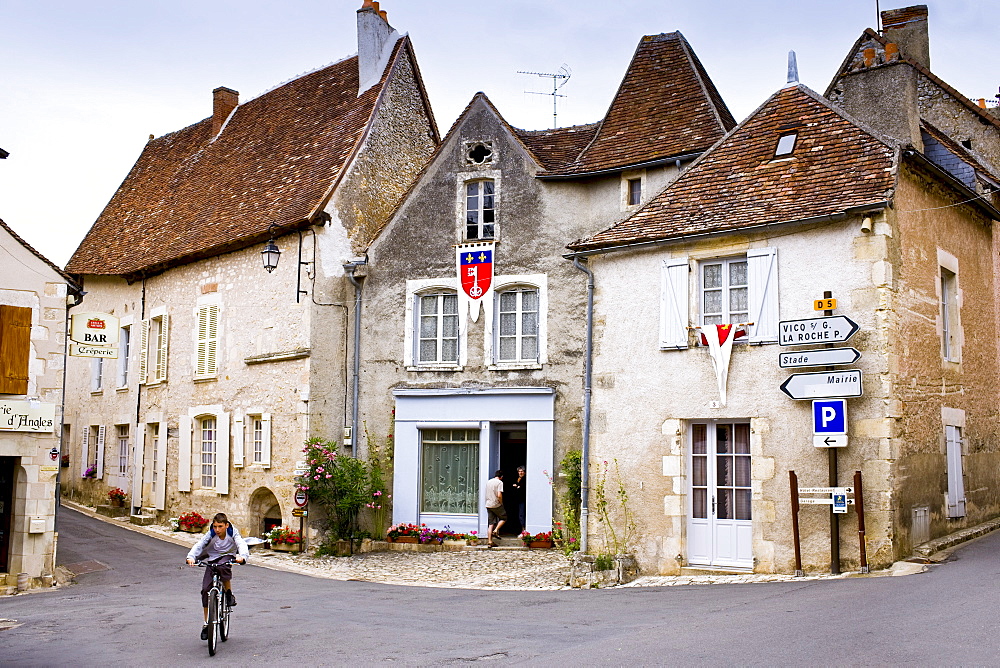 Cyclist in traditional French village of Angles Sur L'Anglin, Vienne, near Poitiers, France